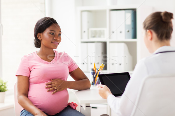 doctor with tablet pc and pregnant woman at clinic Stock photo © dolgachov