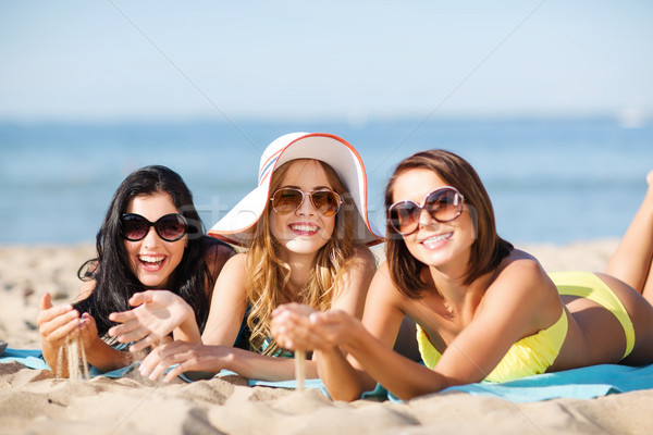 Stock photo: girls sunbathing on the beach