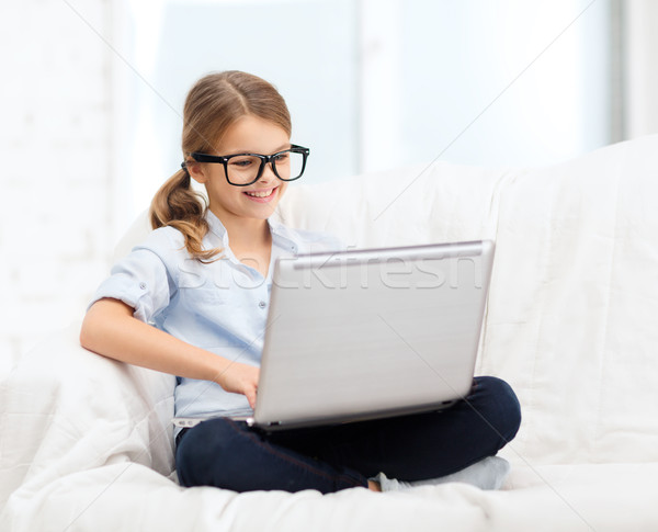 smiling girl in specs with laptop computer at home Stock photo © dolgachov
