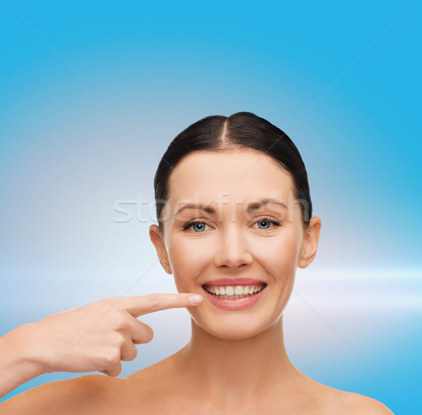 young calm woman pointing to her mouth Stock photo © dolgachov