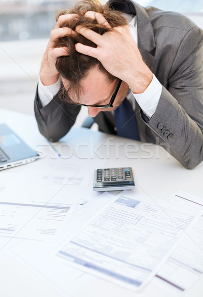 Stock photo: businessman with papres, laptop and calculator