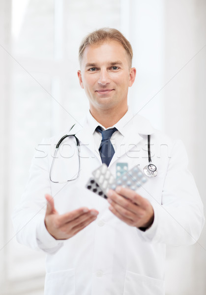 young male doctor with packs of pills Stock photo © dolgachov