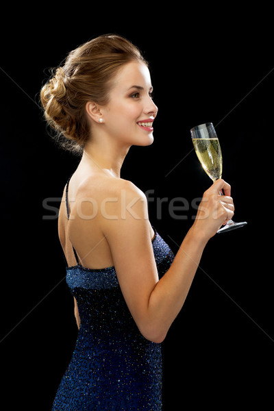 Stock photo: smiling woman holding glass of sparkling wine