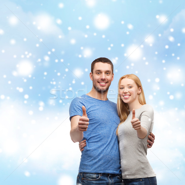 Stock photo: happy couple showing thumbs up and hugging
