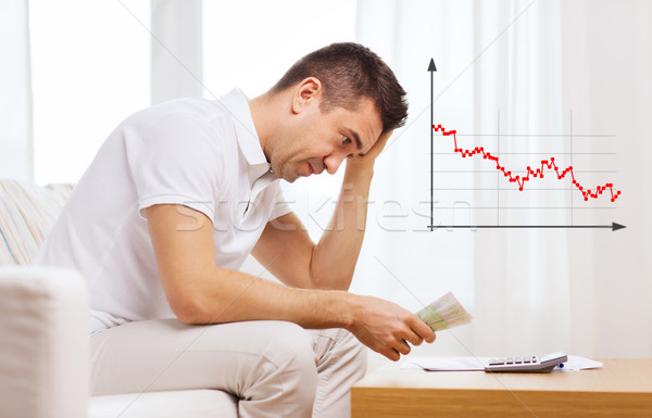 man with money and calculator at home Stock photo © dolgachov