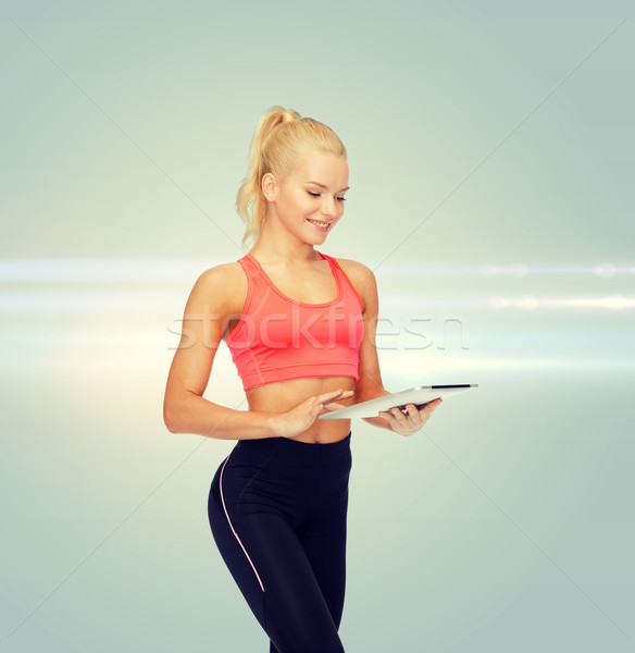 Stock photo: smiling sporty woman with tablet pc computer