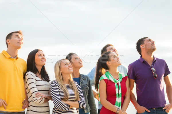 group of happy friends looking up on beach Stock photo © dolgachov