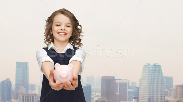 Stock photo: happy girl holding piggy bank on palms