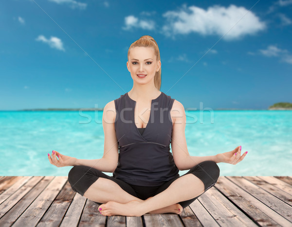 happy young woman meditating in yoga lotus pose Stock photo © dolgachov