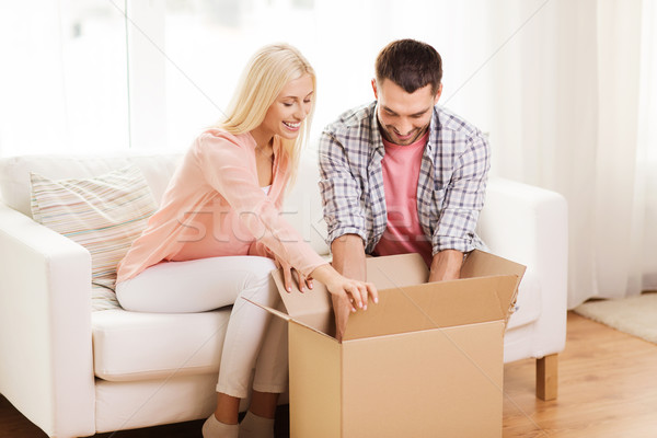 happy couple with cardboard box or parcel at home Stock photo © dolgachov