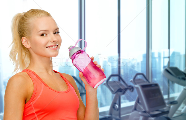 快樂 女子 飲用水 瓶 健身房 人 商業照片 © dolgachov