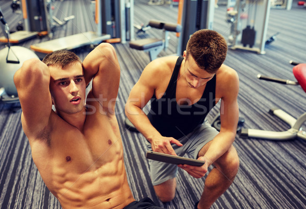 men flexing abdominal muscles in gym Stock photo © dolgachov