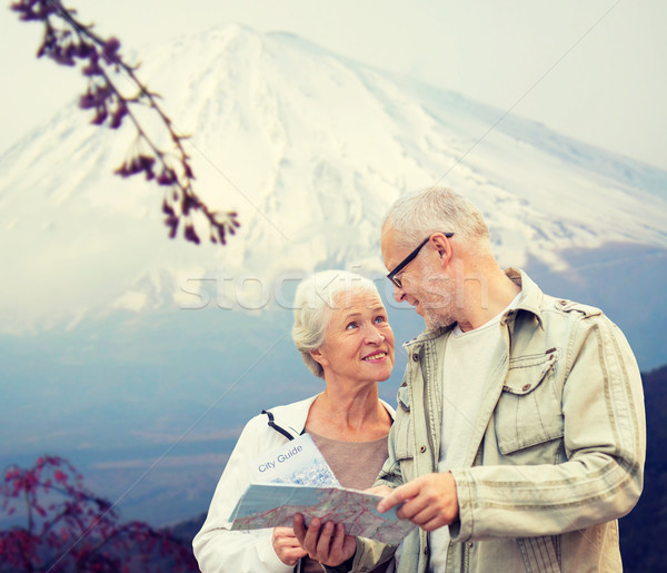 happy senior couple with travel map over mountains Stock photo © dolgachov