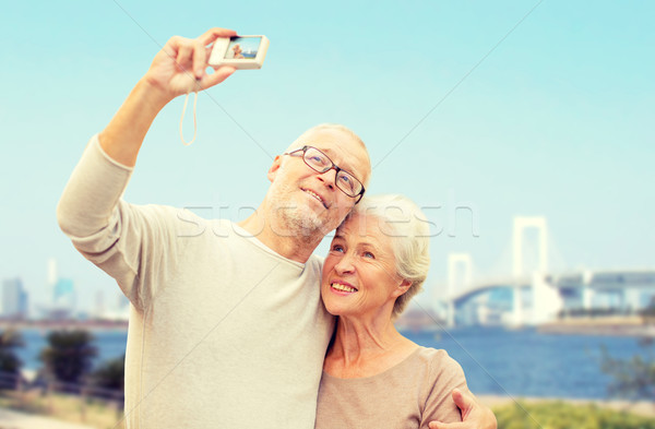 senior couple with camera over rainbow bridge Stock photo © dolgachov