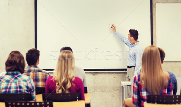 group of students and smiling teacher in classroom Stock photo © dolgachov