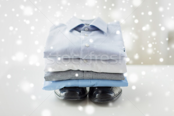 close up of folded male shirts and shoes on table Stock photo © dolgachov