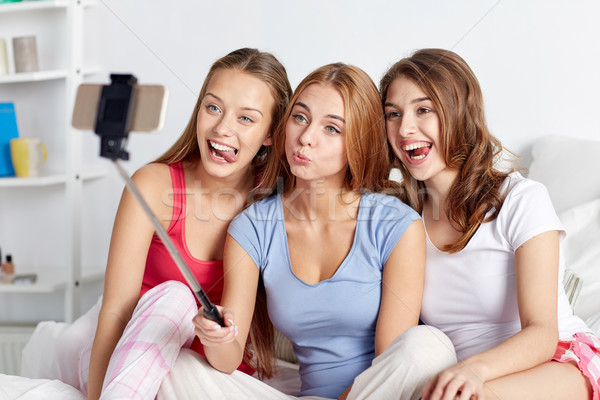 teen girls with smartphone taking selfie at home Stock photo © dolgachov