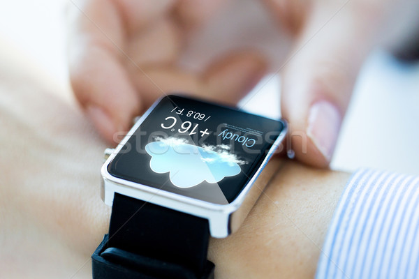 close up of hands with weather icon on smartwatch Stock photo © dolgachov