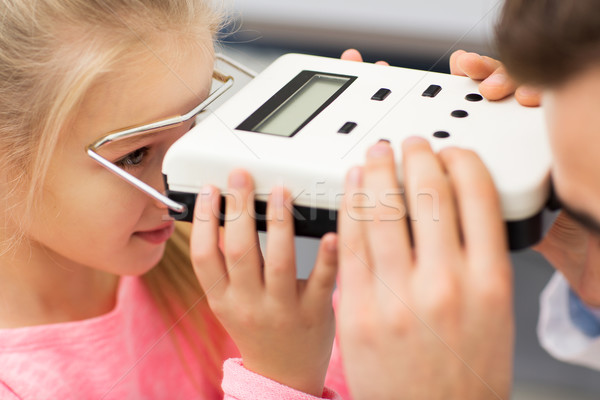 optician with pupillometer and girl at eye clinic Stock photo © dolgachov