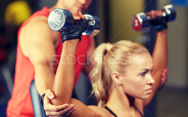 man and woman with dumbbells in gym Stock photo © dolgachov