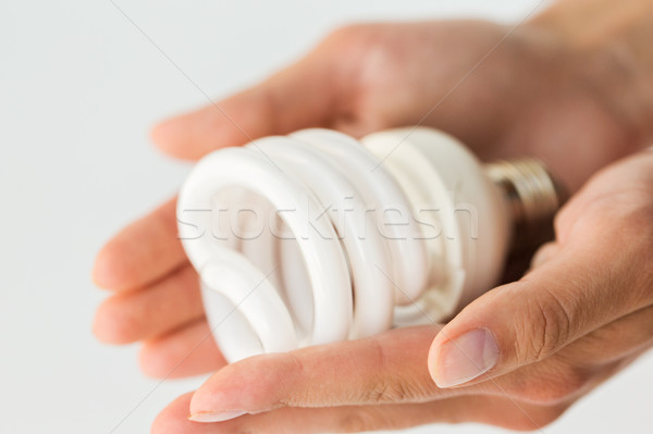 close up of hands holding energy saving lightbulb Stock photo © dolgachov