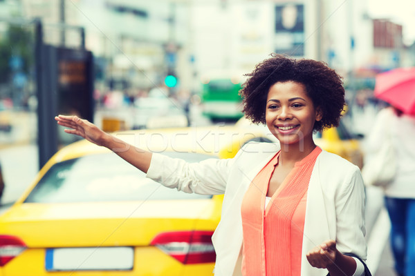 happy african woman catching taxi Stock photo © dolgachov
