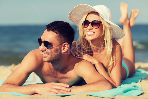 happy couple in swimwear lying on summer beach Stock photo © dolgachov