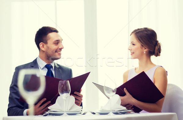 smiling couple with menus at restaurant Stock photo © dolgachov