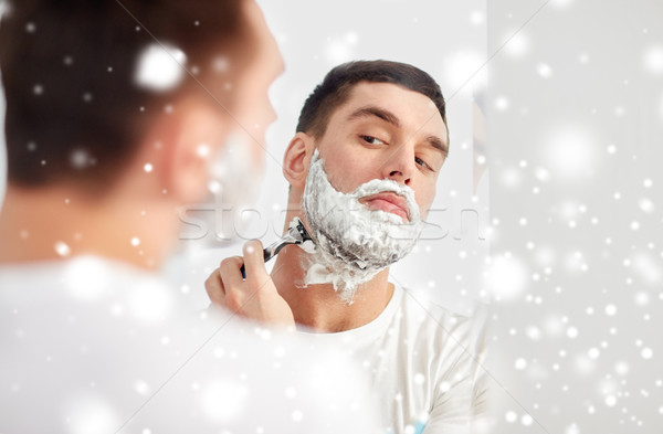 man shaving beard with razor blade at bathroom Stock photo © dolgachov