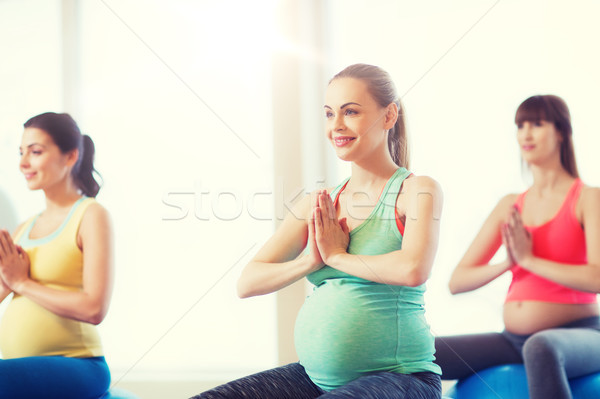 happy pregnant women exercising on fitball in gym Stock photo © dolgachov