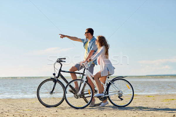 happy young couple riding bicycles at seaside Stock photo © dolgachov