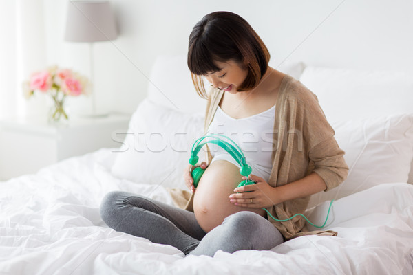 Fericit femeie gravida Căşti acasă sarcină tehnologie Imagine de stoc © dolgachov