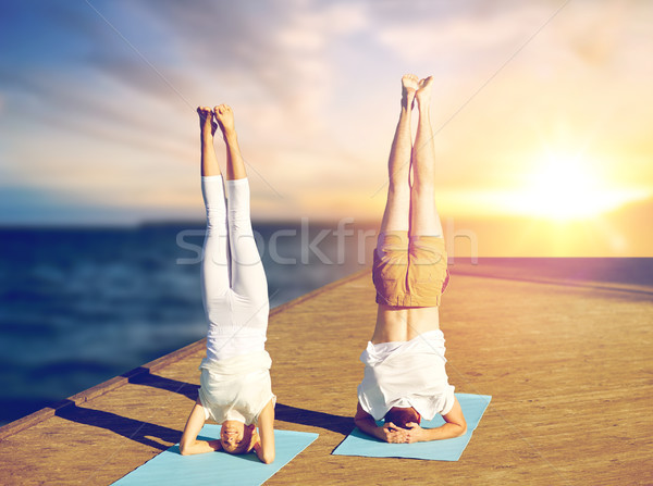 couple doing yoga headstand on mat outdoors Stock photo © dolgachov