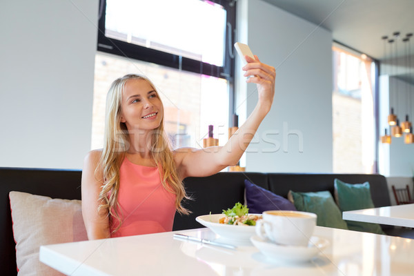 woman with smartphone taking selfie at restaurant Stock photo © dolgachov