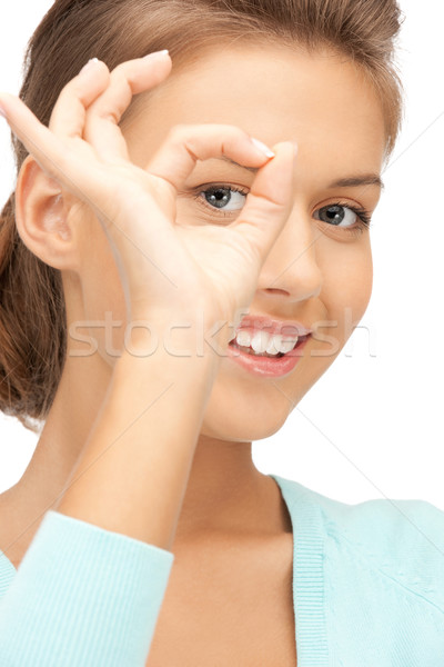 lovely woman looking through hole from fingers Stock photo © dolgachov