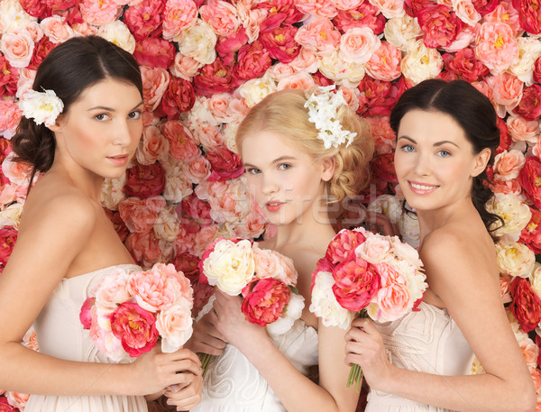 three women with background full of roses Stock photo © dolgachov