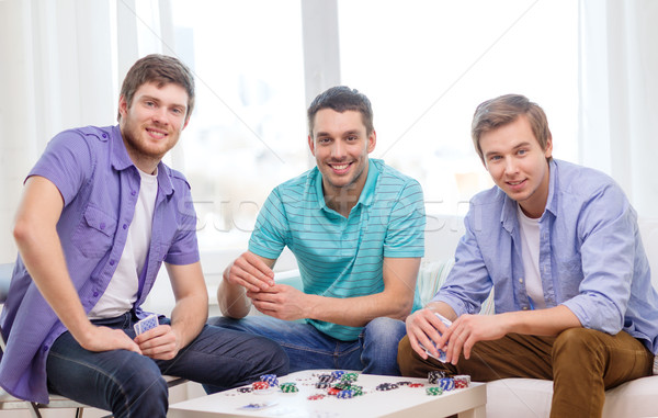 Felice tre maschio amici giocare poker Foto d'archivio © dolgachov