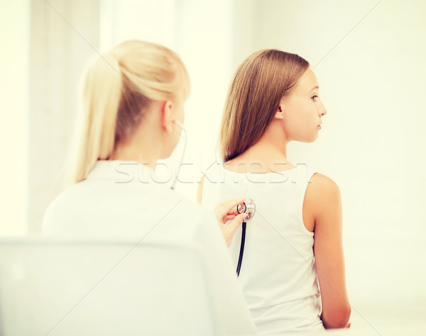 doctor with stethoscope listening to child back Stock photo © dolgachov