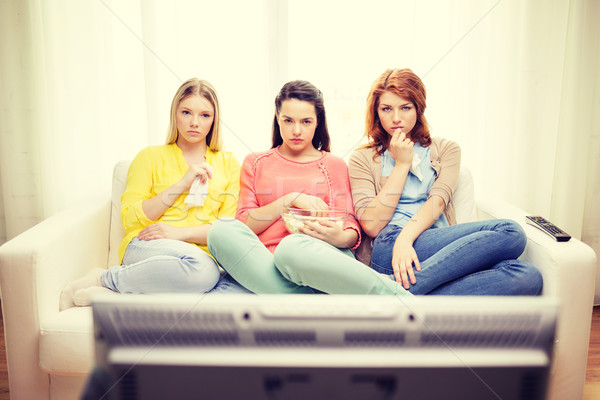 three sad teenage girl watching tv at home Stock photo © dolgachov