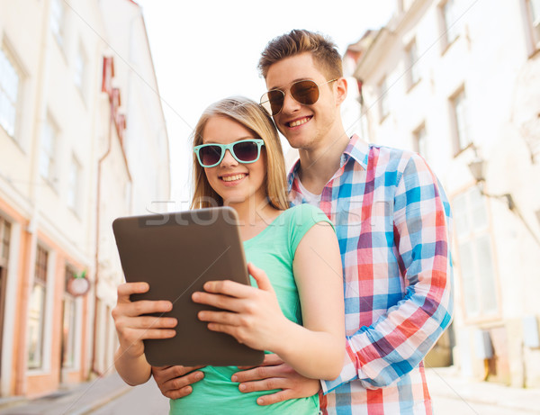 Stock photo: smiling couple with tablet pc in city