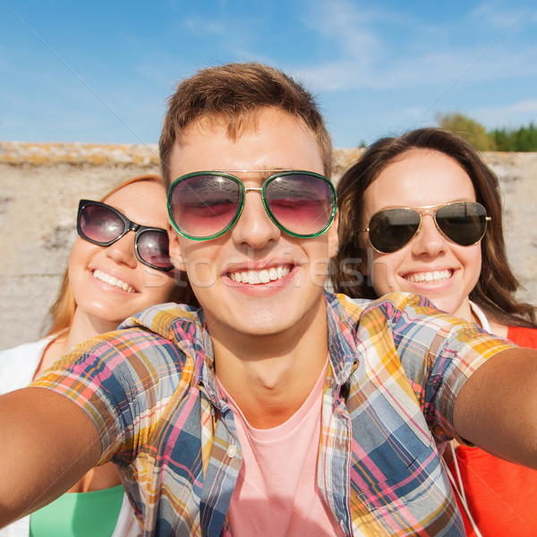 group of smiling friends taking selfie outdoors Stock photo © dolgachov