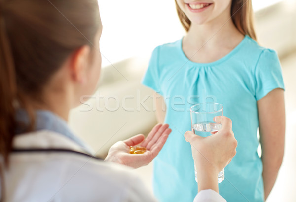 close up of doctor giving medicine to happy girl Stock photo © dolgachov