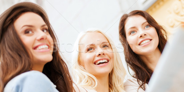 beautiful girls looking into tourist map in city Stock photo © dolgachov