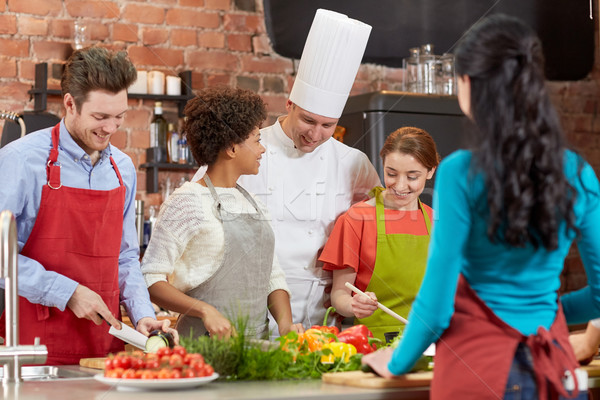 happy friends and chef cook cooking in kitchen Stock photo © dolgachov