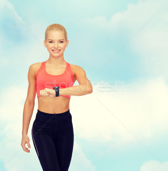 Glimlachende vrouw hartslag monitor hand fitness technologie Stockfoto © dolgachov