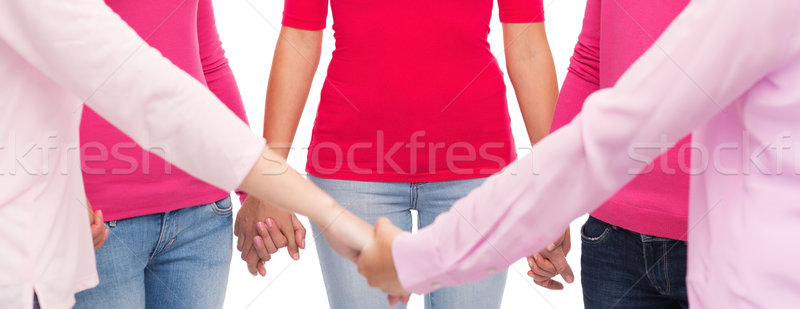 Közelkép nők rózsaszín pólók kéz a kézben egészségügy Stock fotó © dolgachov