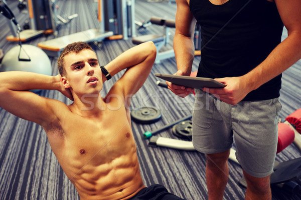 men flexing abdominal muscles in gym Stock photo © dolgachov