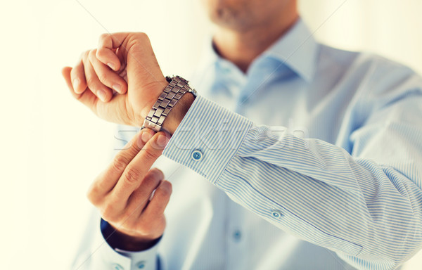 close up of man in shirt fastening wristwatch Stock photo © dolgachov