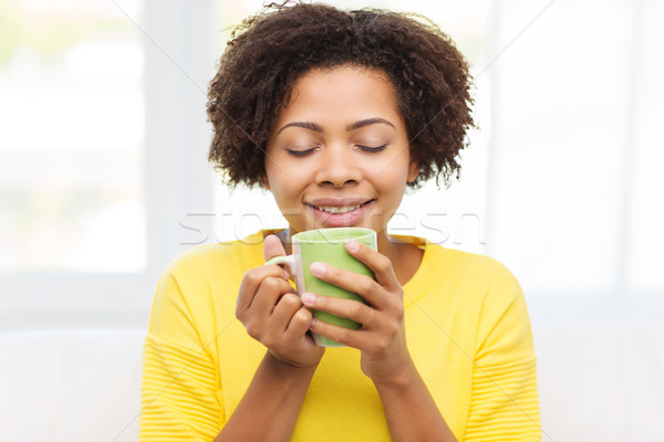 happy african american woman drinking from tea cup Stock photo © dolgachov