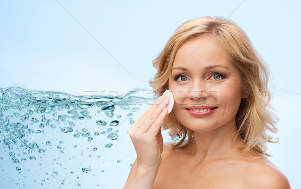 Stock photo: happy woman cleaning face with cotton pad